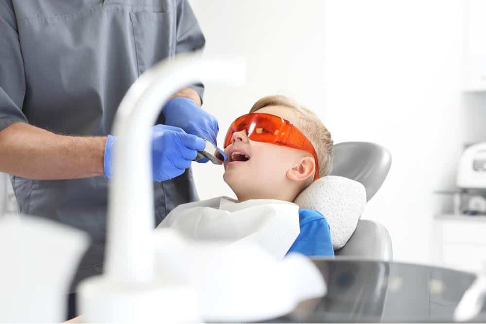 Photo of a child receiving fluoride treatment at the dentist