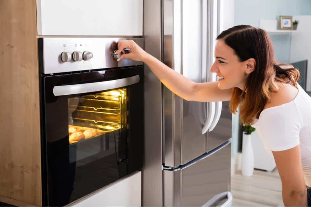 Photo of a woman setting her oven temperature