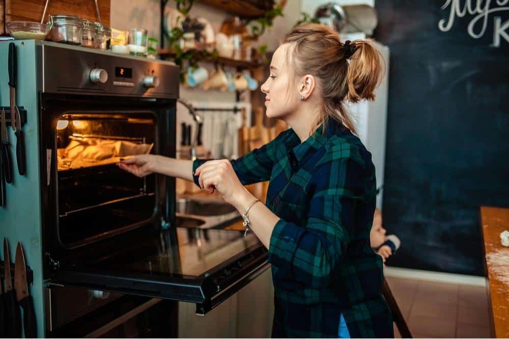Photo of a woman using a functioning oven