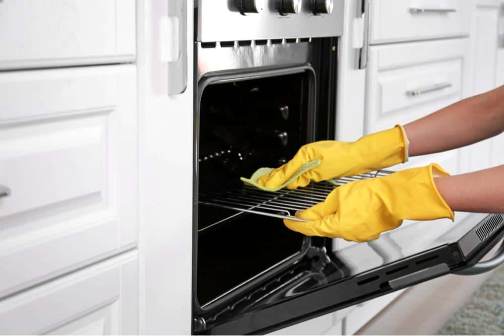 Photo of someone cleaning an oven by hand