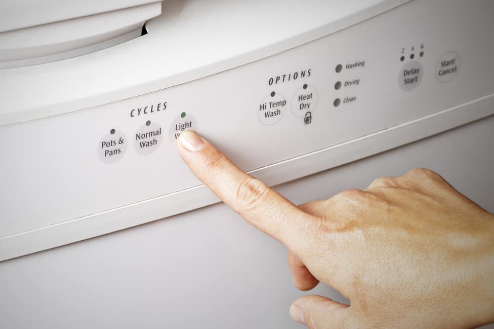 Photo of a person pushing dishwasher cycle buttons