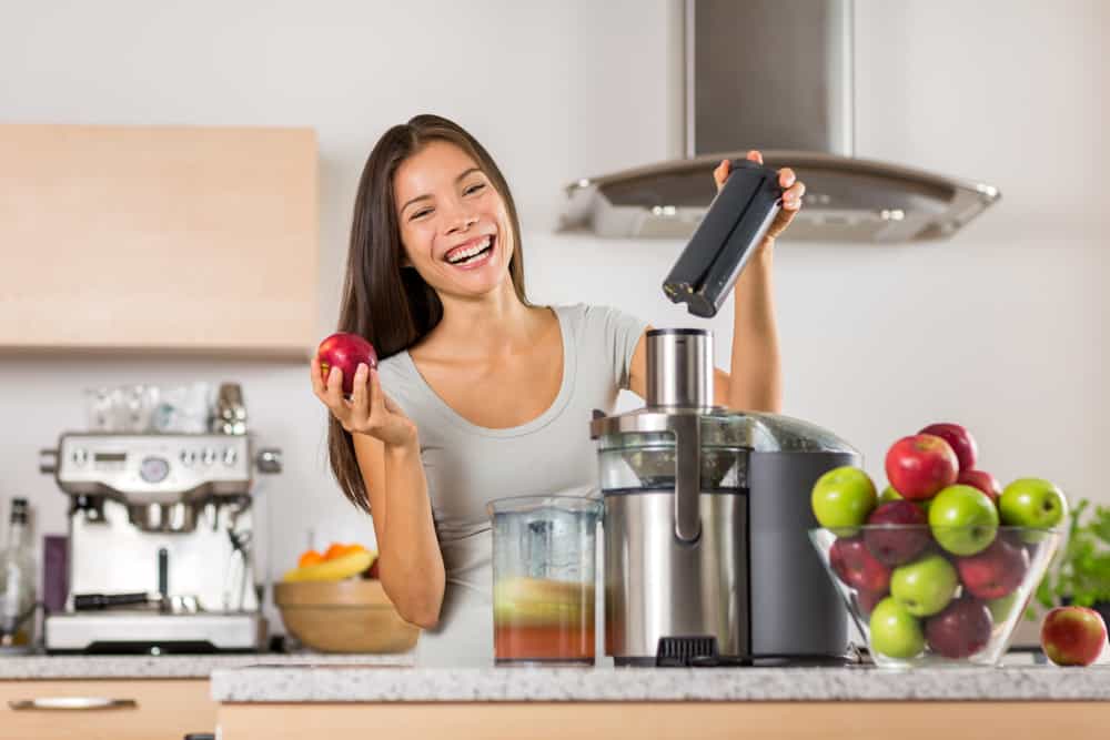 Photo of a woman smiling with a juicing machine