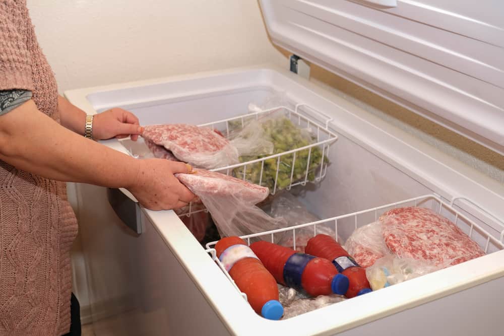 Photo of someone storing food in a freezer