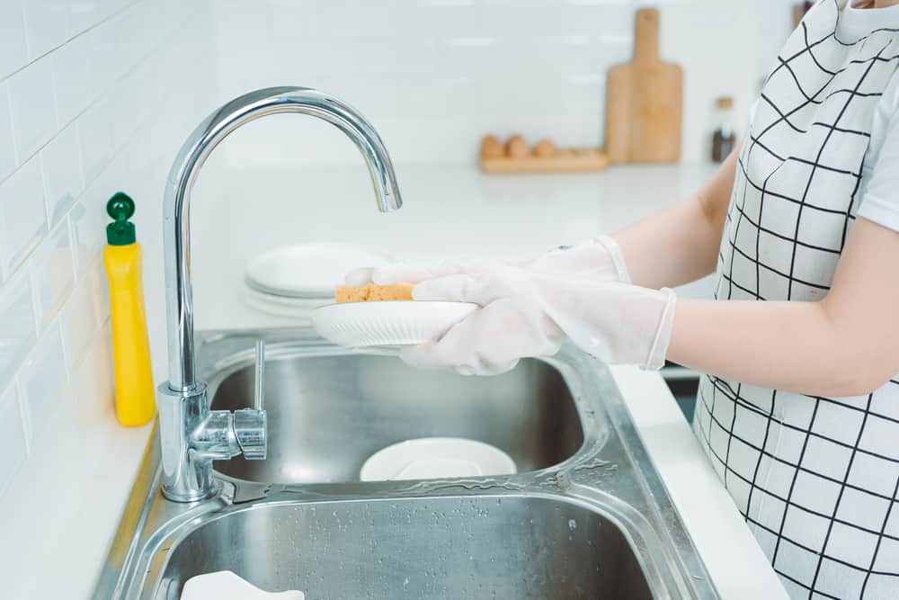 Photo of woman hand washing dishes