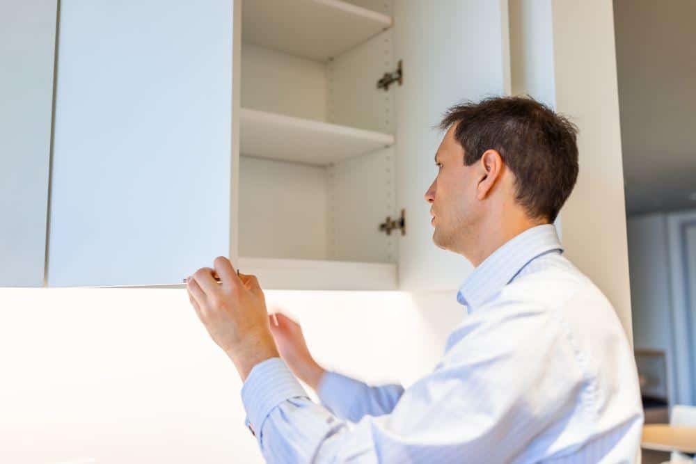 Photo of a Man Examining Cabinets