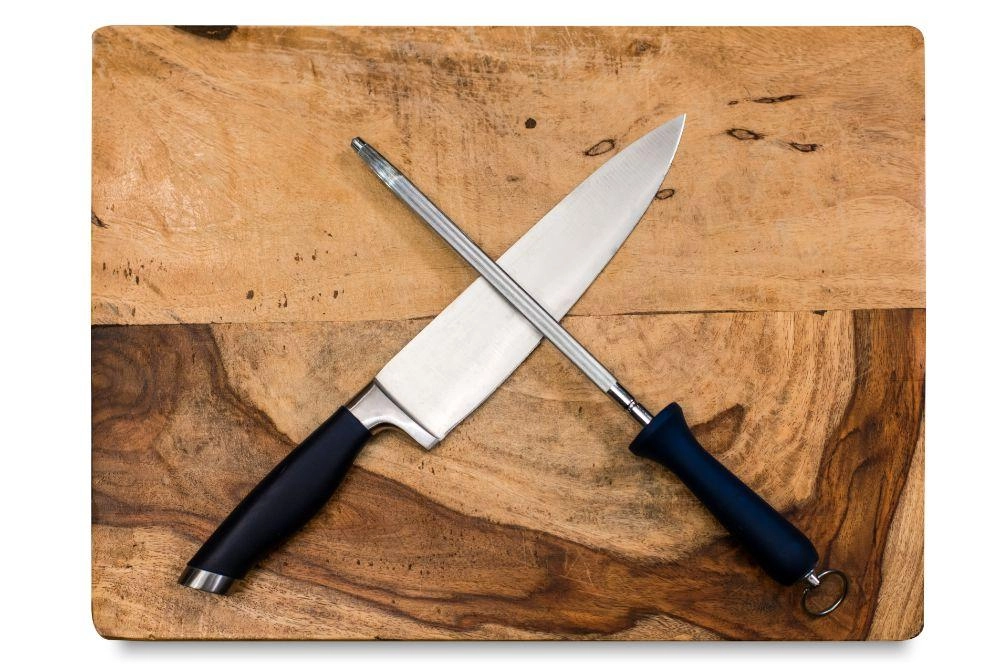 Two knives on a wooden cutting board.