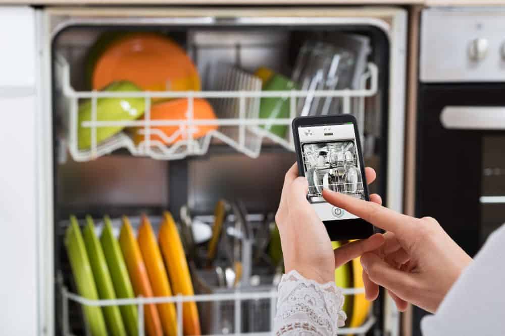 Keywords used: dishwasher, wash cycle

Description: A woman interrupting a dishwasher mid-wash cycle with her smartphone.