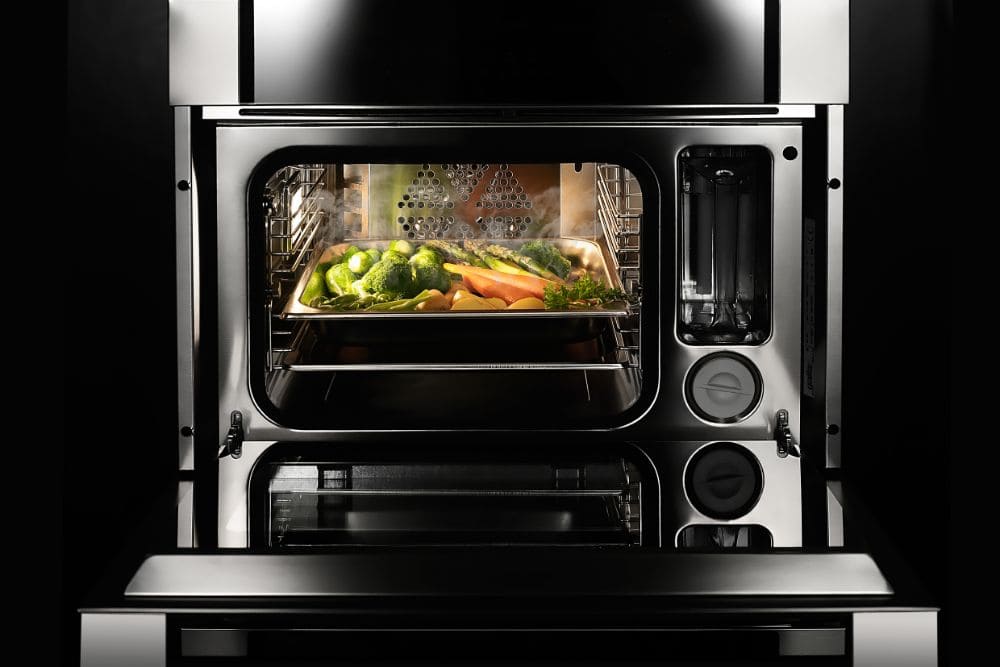 A stainless steel oven with Pyrex freezer-safe vegetables in it.